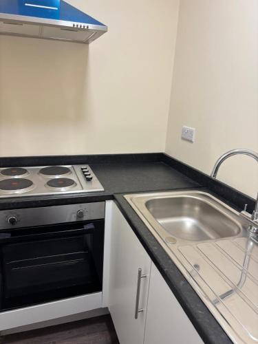 a kitchen with a stove and a sink at The Tudor House Hotel in Nottingham