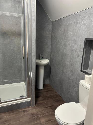 a bathroom with a shower and a toilet and a sink at The Tudor House Hotel in Nottingham