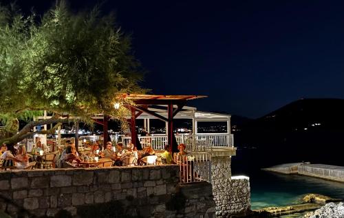 a group of people sitting at a restaurant at night at Apartment Simo in Herceg-Novi