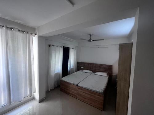 ein Schlafzimmer mit einem Bett in einem Zimmer mit Fenstern in der Unterkunft Time and space infinity in Muthugadahalli