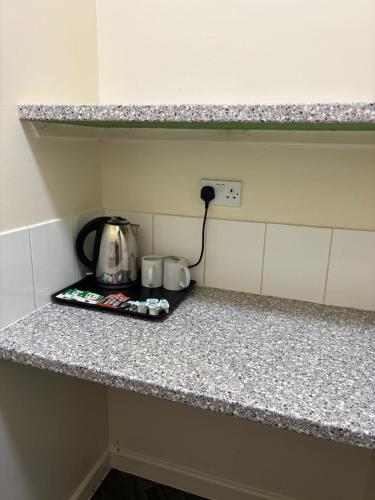 a kitchen counter with a tea kettle and cups on it at The Tudor House Hotel in Nottingham