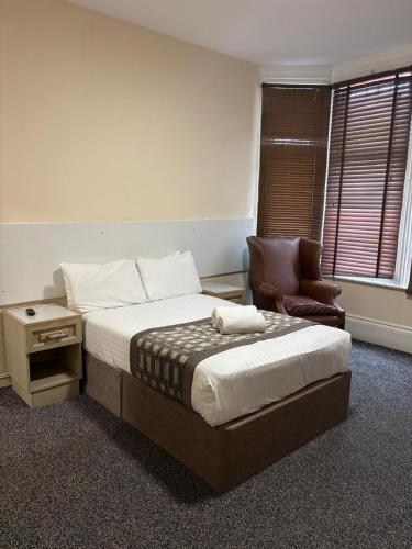 a hotel room with a bed and a chair at The Tudor House Hotel in Nottingham