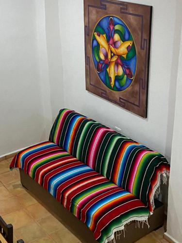a colorful couch sitting in a room with a painting at Vistalmar House in Isla Mujeres