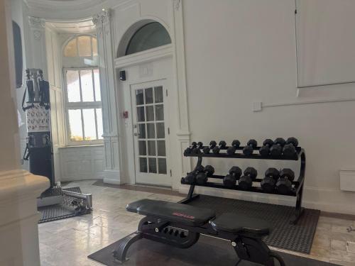 a room with a gym with a bench and weights at Glorestays in Baltimore