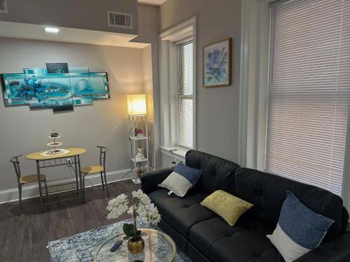 a living room with a black couch and a table at Glorestays in Baltimore