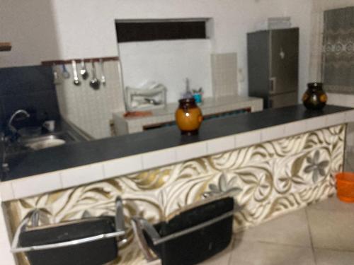 eine Küche mit einer Theke mit zwei Stühlen in der Unterkunft Upepo house watamu in Watamu