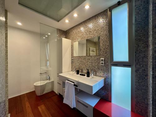 a bathroom with a sink and a toilet and a mirror at Imperiale Golf House in Bétera