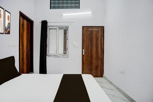 a bedroom with a bed and a wooden door at HOTEL O VIP HILL HOMESTAY in Mājra