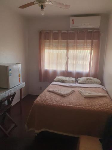 a bedroom with a large bed with a window at Hotel Central in Arroio do Meio