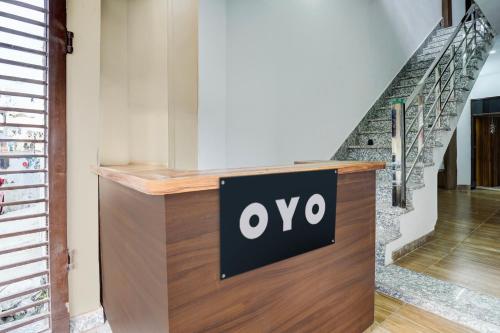 a sign on a counter in a room with stairs at HOTEL O VIP HILL HOMESTAY in Mājra