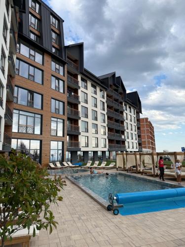 an apartment complex with a swimming pool in front of a building at Fashion Residence Hill in Kopaonik