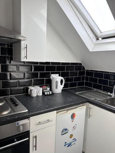 a kitchen with a black and white tile wall at The Tudor House Hotel in Nottingham
