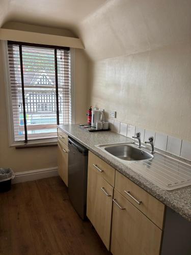 a kitchen with a sink and a window at The Tudor House Hotel in Nottingham