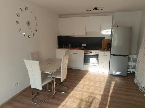 a kitchen with a table and a refrigerator at Wohnung auf dem Bezenberg in Kaiserslautern