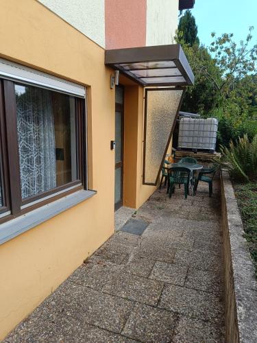 a patio with a table and a window at Wohnung auf dem Bezenberg in Kaiserslautern