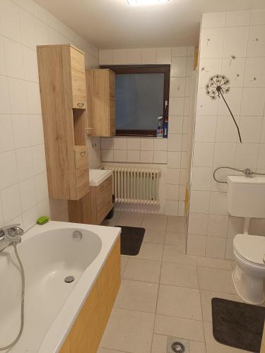 a bathroom with a tub and a toilet and a sink at Wohnung auf dem Bezenberg in Kaiserslautern