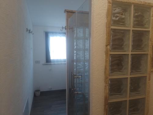 a glass shower door in a room next to a wall at Villa Annamaria in Torino di Sangro