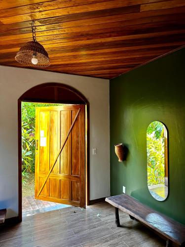 a room with a wooden door and a bench at Vila Ypáwa 150 m centro 30 m praia lago verde in Alter do Chao