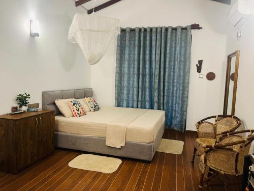 a small bedroom with a bed and a window at Mashi's Villa in Sigiriya