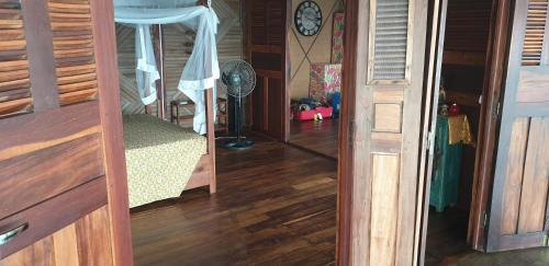 a room with a bed and a fan and a mirror at Lodge Villa MAYANKI in Dzamandzar