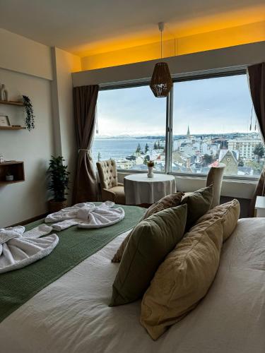a bedroom with a large bed with a large window at Studio vista al lago in San Carlos de Bariloche