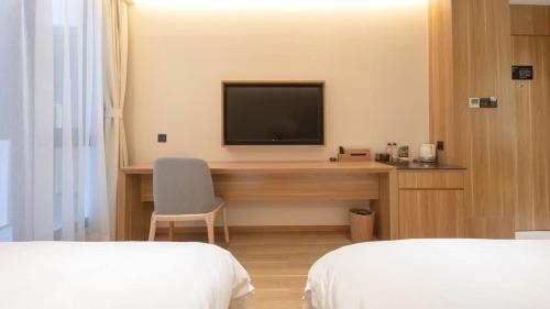 a hotel room with a desk with a television on it at WeLight Hotel in Beijing