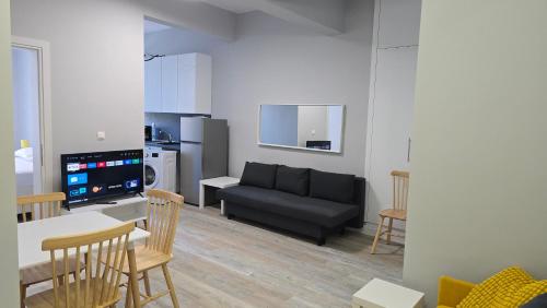un soggiorno con un divano, un tavolo e delle sedie di KYANA Luxury KVA a Kavala