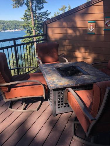 a table and chairs on a deck with a fire pit at Townhouse In Bayview in Bayview