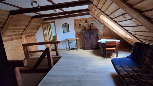 an attic room with a staircase and a table at domek w pobliżu jeziora in Czarnówka