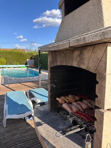 a outdoor grill with hot dogs on it next to a pool at Village villa, private pool, canal du midi in Argens Minervois