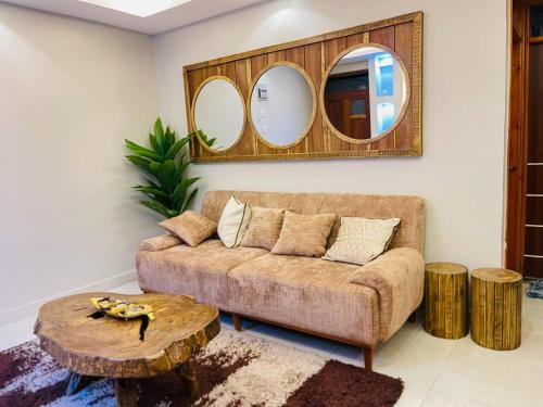 a living room with a couch and two mirrors at Luxurious Cozy Apartment in Kampala
