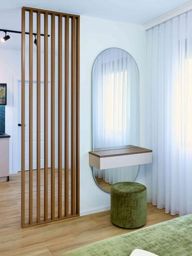 a room with a table and a stool and a mirror at Riian Luxury Apartments in Ulcinj