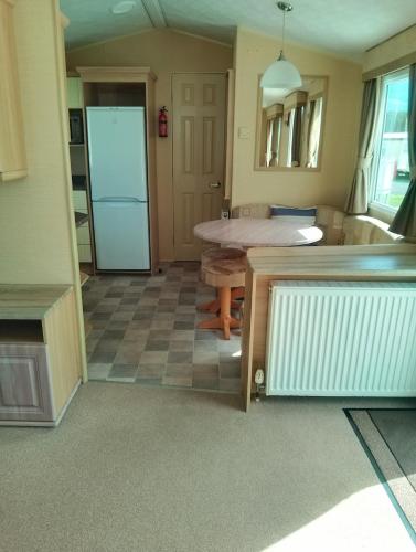 a living room with a table in a room at Comfy caravan in Eyemouth in Eyemouth