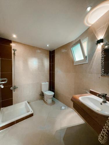 a bathroom with a sink and a toilet and a tub at Tarakhan Hotel in Dahab
