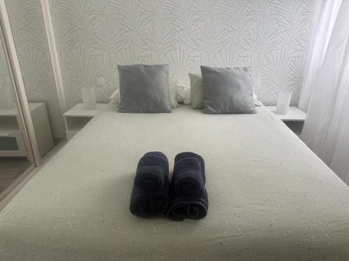 a pair of slippers are sitting on a bed at Paraíso playero en Las Palmas in Las Palmas de Gran Canaria
