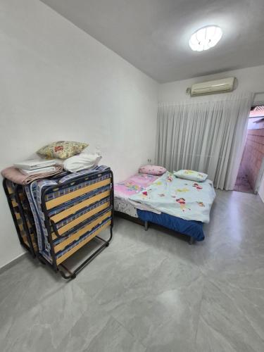 a bedroom with two twin beds and a window at הבית של גלית in Ashqelon