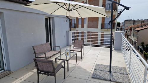 a patio with two chairs and a table with an umbrella at Appartamento moderno a 500mt dal mare in Civitanova Marche