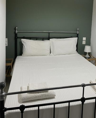 a bed with a black frame and white sheets and pillows at City Apartment in Ierapetra
