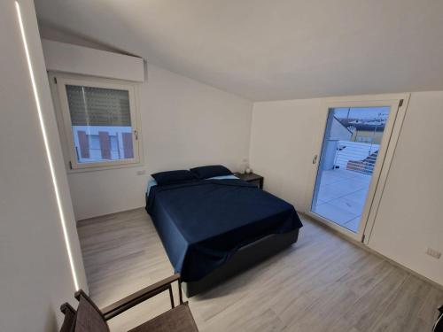 a bedroom with a bed and a large window at Appartamento moderno a 500mt dal mare in Civitanova Marche