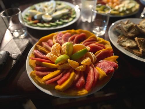 a bowl of fruit on a table with plates of food at Sea Breeze Stay in Negombo