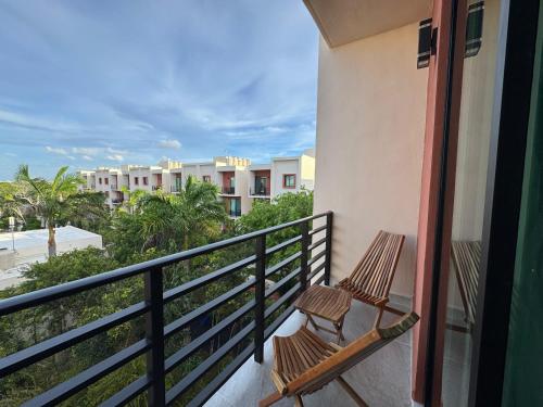 a balcony with two chairs looking out at the ocean at OMBU Apartment New, equipped, 2 bedrooms, 2 bathrooms, pool in Cancún