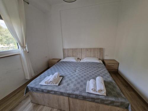 a bedroom with a bed with two towels on it at Apartament , White Rocks, Drimadhe in Himare