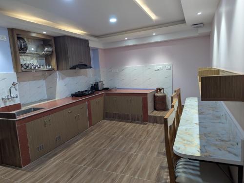 cocina grande con encimera y mesa en Jhigu Casa, en Kirtipur