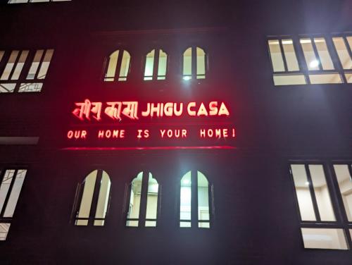 una señal en el lateral de un edificio con ventanas en Jhigu Casa, en Kirtipur