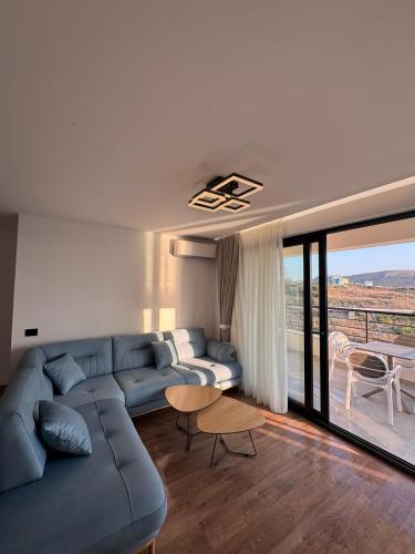 a living room with a blue couch and a table at Alpha Panorama in Sarandë