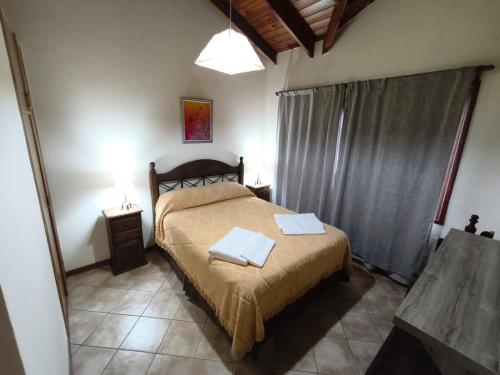 Un dormitorio con una cama con dos toallas encima. en Jardín del Piltri, en El Bolsón