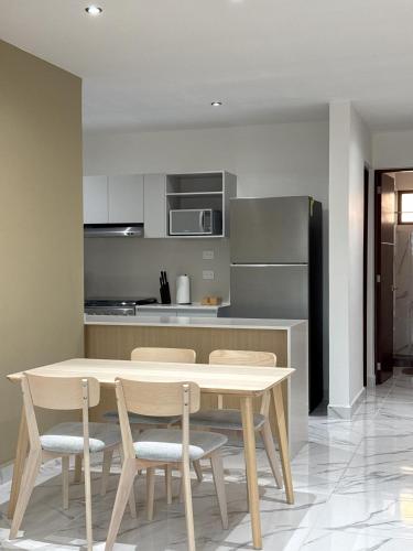 a kitchen with a wooden table and chairs in a room at OMBU Apartment New, equipped, 2 bedrooms, 2 bathrooms, pool in Cancún
