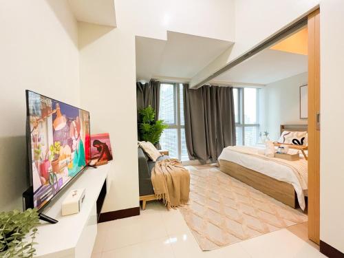 Un dormitorio con una cama y un televisor de pantalla plana. en Stylish 1BR Prime BGC Uptown near Hyatt #upt119c, en Manila