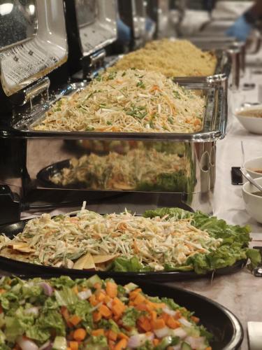 a buffet with three trays of different types of food at Tranquil Riverview Inn in Kottayam