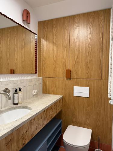 a bathroom with a sink and a toilet and a mirror at Kalbornia LAKE & POOL HOUSE by JWPM in Brzeźno Mazurskie